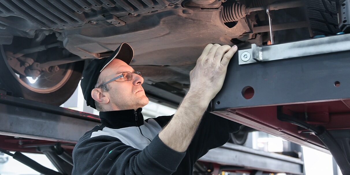 Mecânico arrumando amortecedores do veiculo