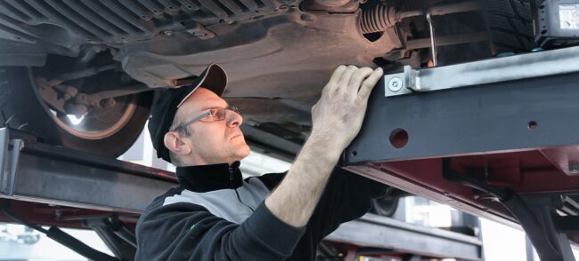 Mecânico arrumando amortecedores do veiculo